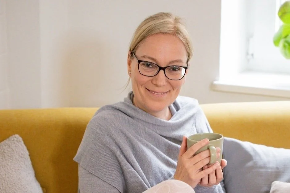 Daniela Meinl mit einer Tasse auf dem Sofa